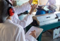 Technicians examining olive oil in factory